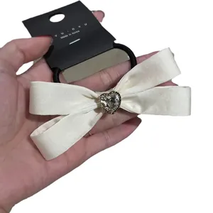 Elegant cream satin bow hair clip with heart crystal and black elastic band for women