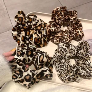 Lot de quatre chouchous en velours à imprimé léopard en diverses couleurs sur plateau