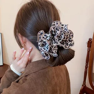 Chouchou élastique à imprimé léopard pour femme porté dans un chignon bas élégant
