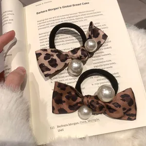 Detail of vintage leopard bow hair ties with faux pearls on an open recipe book