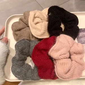 Set of six chunky knit scrunchies in various autumn colors in a tray