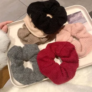 Detail shot of six colorful handmade knitted scrunchies with soft woven texture