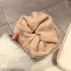 Detailed view of handmade apricot knitted scrunchie showing delicate woven wool texture