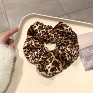 Vue détaillée d'un chouchou en velours à motif léopard sur un plateau beige élégant