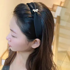 Diadema elegante de satén negro con lazo de diamantes dorados en modelo real