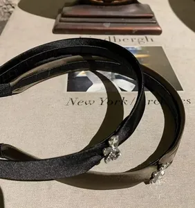 Detalle de diademas de satén con cristales plateados en colores negro y verde oscuro