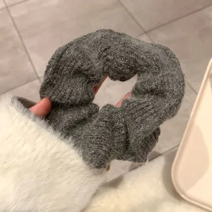 Detailed view of handmade chunky knit dark grey scrunchie with soft wool texture