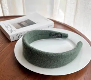 Macro detail of wool felt headband in sage green with handmade woven label