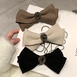Three-piece wool bow hair clips set in brown, cream and black with rhinestone accents