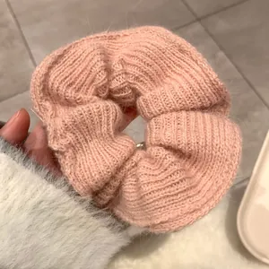 Close-up of pink hand-knitted mohair scrunchie showing soft fuzzy texture and elastic band