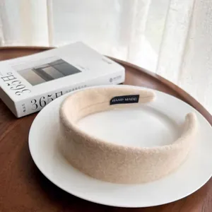 Elegant wide beige wool felt headband with handmade label on white plate