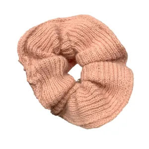 Pink hand-knitted woolen scrunchie with rib-knit texture for girls' autumn hairstyles