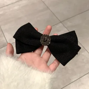 Detail of wool bow hair clip featuring a vintage crystal buckle with rhinestone decor