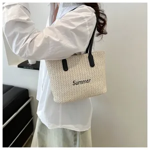 Détail du sac cabas en paille tressée avec broderie Summer noire et anses de portage