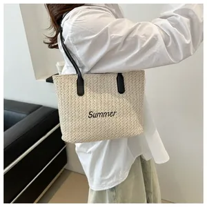 Détail du sac cabas en paille tissée avec broderie Summer et poignées en cuir