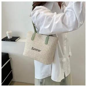 Détail de la broderie Summer sur un sac en paille avec anses en cuir vert, décor chic