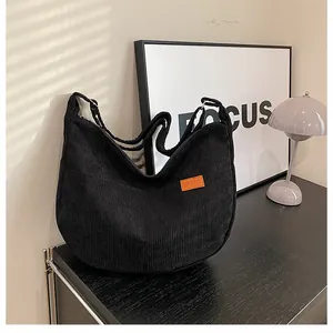 Detail of black corduroy crossbody bag featuring a SPORT leather patch and front pockets