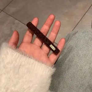 Brown teddy plush hair clip with Lovedays tag shown in hand for daily wear