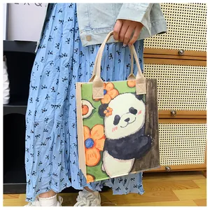 Detail of felt tote bag with cartoon panda print and green background floral design