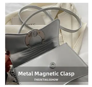 Vue détaillée du sac bandoulière argenté montrant le fermoir magnétique et la texture