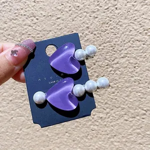 Set di due fermagli per capelli a cuore viola con perline su cartoncino espositivo