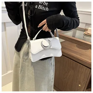 Détail du sac bandoulière blanc à motif litchi avec une boucle argentée en lune