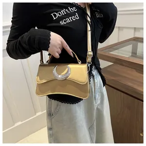 Détail du sac bandoulière doré métallisé avec boucle lune argentée et base ondulée