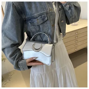 Détail de boucle lune argentée sur un sac à bandoulière carré à texture grainée