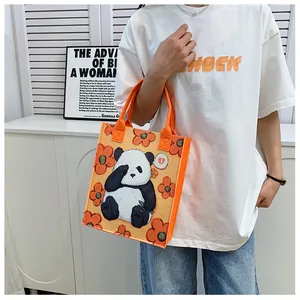 Detail of orange felt tote bag with panda illustration and sturdy fabric handles