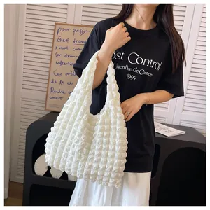 Detailed macro view of a white popcorn textured handbag with pleated bubble fabric finish