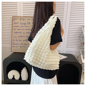 Detailed view of white popcorn texture fabric on a minimalist shoulder tote bag