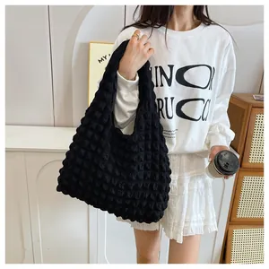 Detail view of the black ruched texture and soft fabric on this stylish tote bag