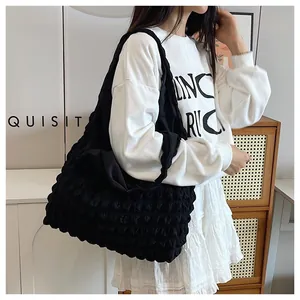 Macro view of textured black bubble fabric and spacious design on a stylish tote bag