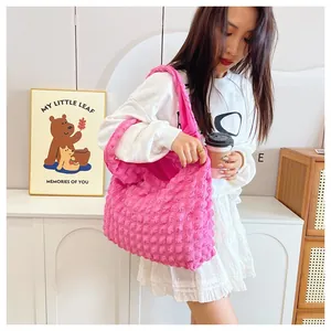 Detailed view of large pink ruched quilted tote bag showing textured bubble fabric finish