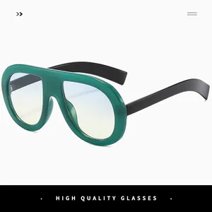 Detail view of oversized dark green sunglasses with wide black temples and gradient lenses