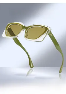Détail de lunettes de soleil œil-de-chat carrées avec verres verts et monture bicolore