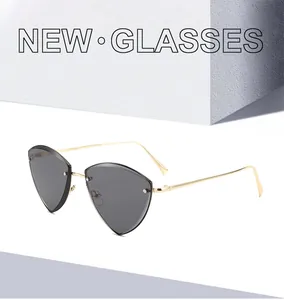 Detail of trendy triangle rimless sunglasses with dark grey lenses and gold metal temples