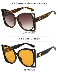 Detail view of tortoiseshell and black oversized sunglasses with gold metal ring accents