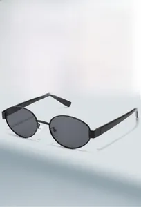 Close-up of vintage oval sunglasses with black frames and dark grey UV lenses