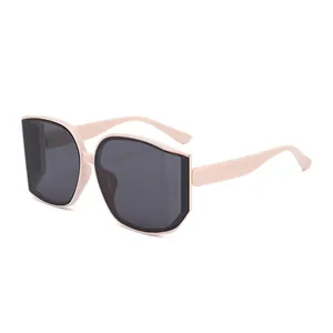 Modieuze oversized nude roze zonnebril met grijze glazen en gouden metalen accenten