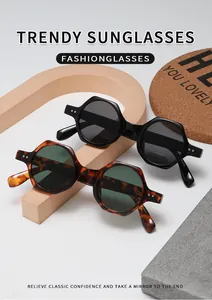 Détail de lunettes de soleil géométriques en noir brillant et écaille avec rivets en métal
