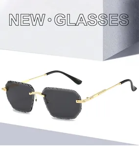 Close-up of rimless polygon sunglasses featuring diamond-cut gray lenses and gold frames