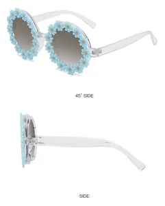 Detail view of round frame children sunglasses with blue daisy floral decor and clear arms