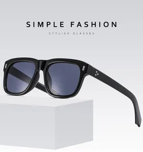 Detail of square black sunglasses with metal triple-rivet decor on minimalist stand