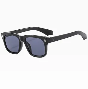 Detail view of retro square black frames with silver metal rivets and grey lenses
