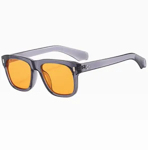 Detail of square resin sunglasses with silver rivets and bright orange lenses