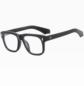 Detail of black thick frame sunglasses with silver stud accents and blue light lenses