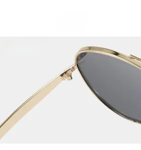 Close-up of sturdy metal hinges and golden frame on premium aviator sunglasses
