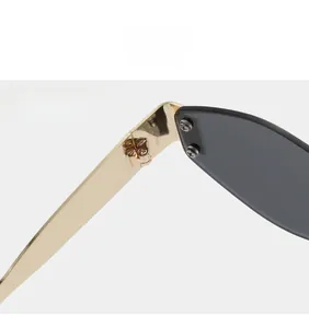 Detailed close-up of sturdy gold metal hinges on rimless retro rectangular sunglasses