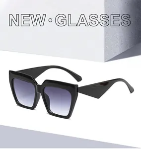 Detail of oversized black cat-eye sunglasses with gradient lenses and triangle temples